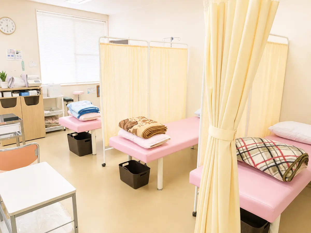 つつみ脳神経外科クリニックの点滴室。淡いピンク色のベッドが、カーテンで仕切られて並んでいる。