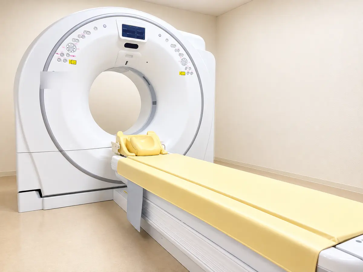 つつみ脳神経外科クリニックのCT検査室。輪の形をした白い装置と、検査用の黄色いベッドが写っている。